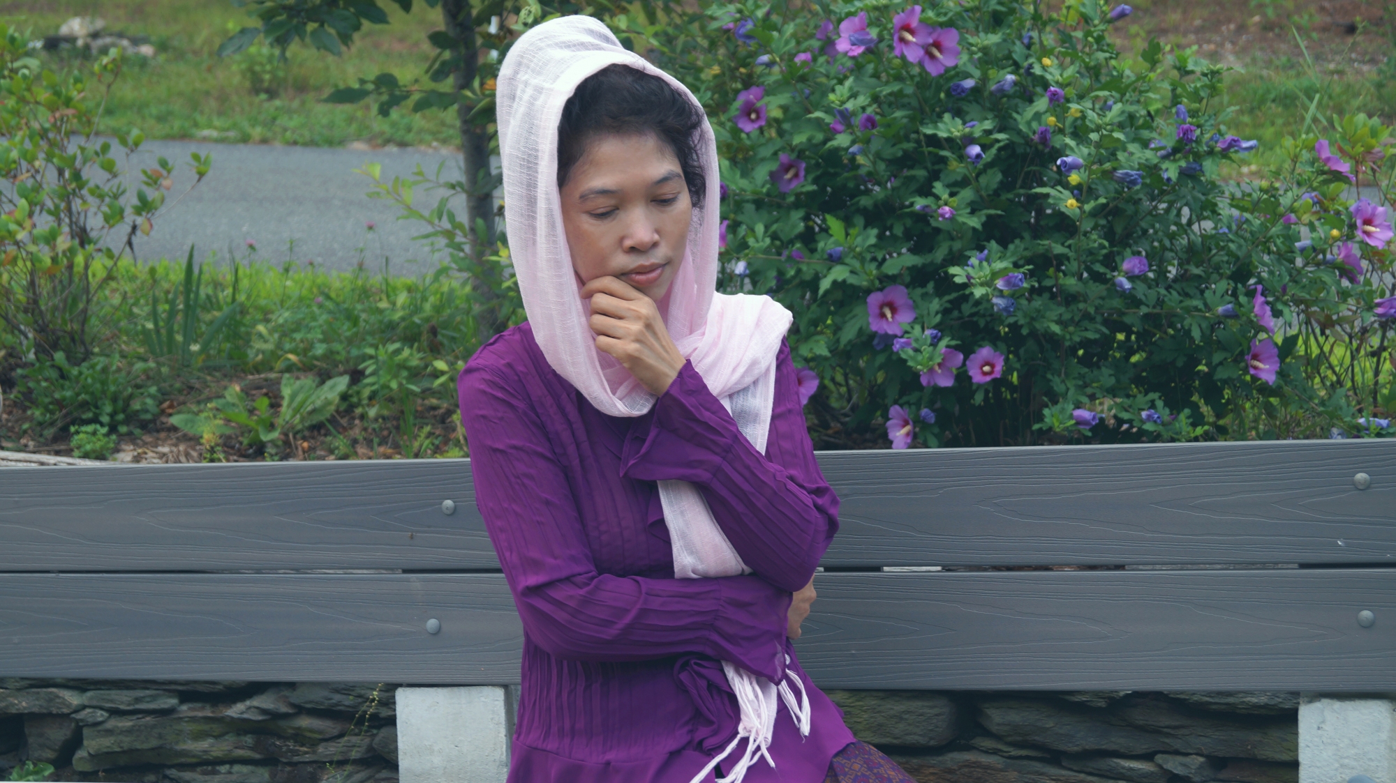 Jendhamuni near purple flowers at Wat Kiryvongsa on August 8, 2020